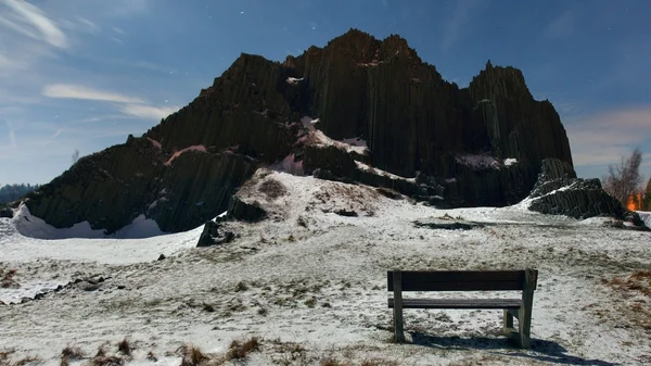 Gipfel von Basaltsäulen bedeckt mit Schnee, blauer Himmel im Hintergrund. Vollmondnacht, Mitternacht. — Stockfoto