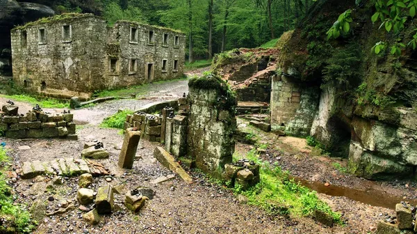 Ruin of old water abandoned mill house, stony walls, windows, empty dry millrace. — Stock Photo, Image