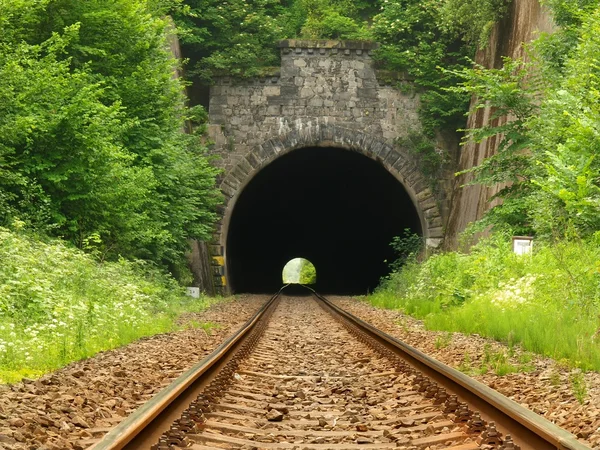View into old railway tunnel, rusty rails and oiled sleepers. — Stock Photo, Image