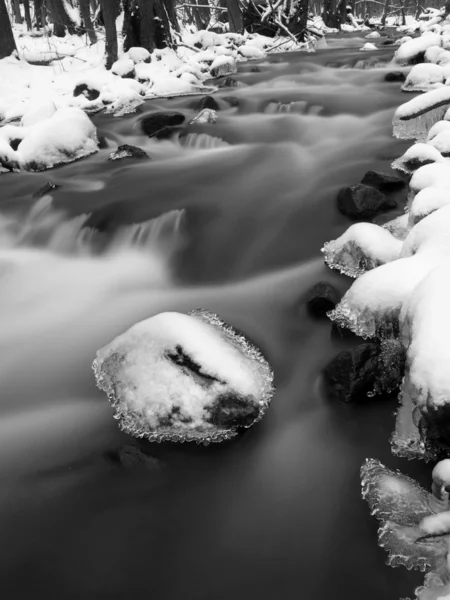 Evening winter view to icicles, icy branches and boulders into chilling stream. Reflections in icicles, blur white foam. — Stock Photo, Image