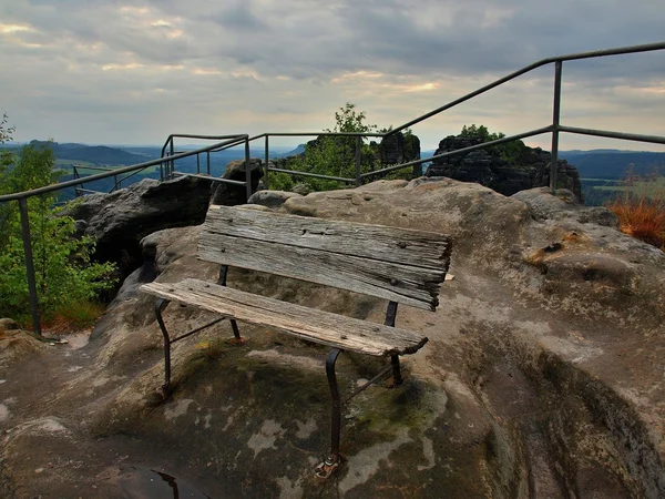 Sommerabend vor Sturm am Gipfelweg in der Sächsischen Schweiz, grauer Himmel über Sandsteinfelsen. Holzbank am Hauptaussichtspunkt. — Stockfoto