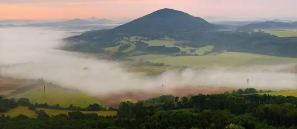 Blick in die neblige Landschaft mit Büschen, Wäldern, Dörfern, Teichen im Morgensonnenaufgang. — Stockfoto