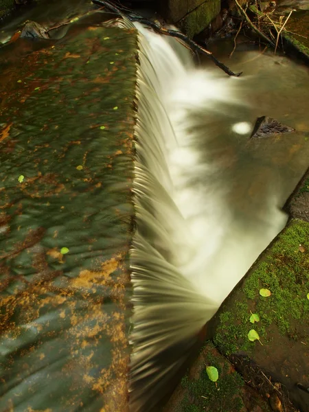 Piccola diga sul torrente di montagna, l'acqua scorre sui massi di basalto . — Foto Stock