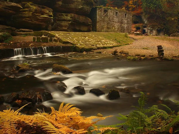 View over dark mountain river with high water level after heavy rains to ruin of stony water mill. — Stock Photo, Image