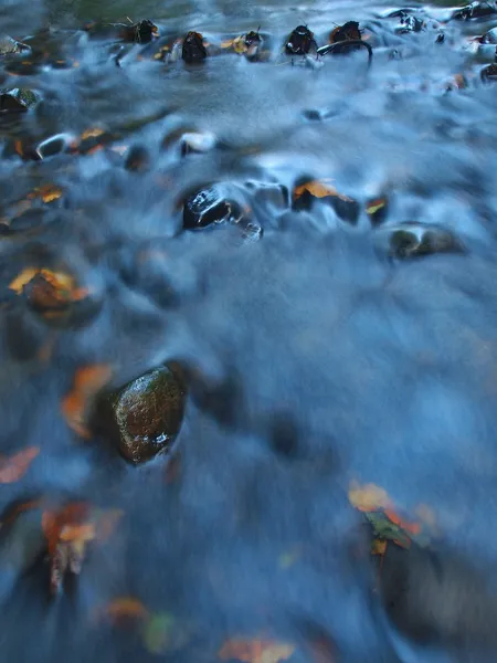 Pietre di basalto in acqua limpida di fiume di montagna, foglie colorate da pioppo tremulo e acero. Onde sfocate, riflessi nel livello dell'acqua . — Foto Stock