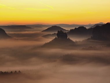 Sunrise güzel dağ çek-Saksonya İsviçre. kumtaşı doruklarına sisli arka plandan arttı, sis turuncu güneş ışınları nedeniyle olduğunu.