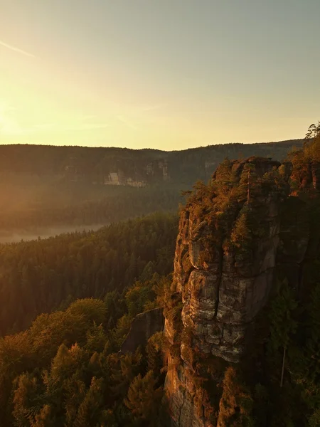 Sonnenaufgang in einem wunderschönen Berg der Tschechisch-Sächsischen Schweiz. Sandsteingipfel vor nebligem Hintergrund, der Nebel ist orange durch Sonnenstrahlen. — Stockfoto