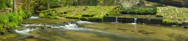 小山河上的砂岩堰的废墟。流流过砂岩块并使乳白色水. — 图库照片