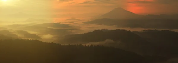 Lever de soleil dans une belle montagne de Bohême-Saxe Suisse. Les sommets et les collines de grès ont augmenté à partir du fond brumeux, le brouillard est orange en raison des rayons du soleil . — Photo