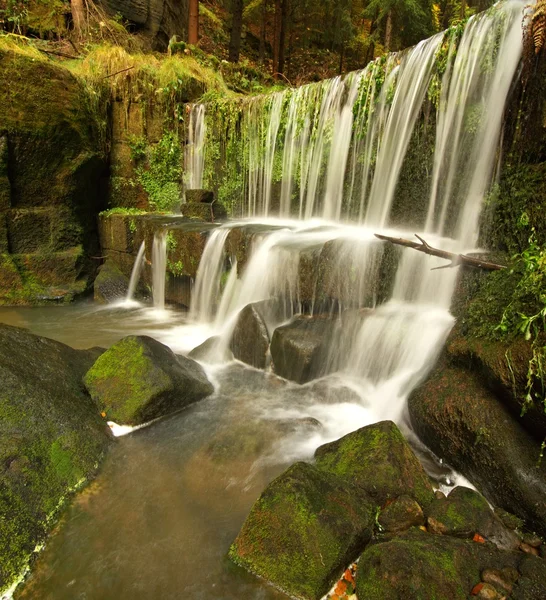 Cascade de petit barrage sur le ruisseau de montagne, l'eau coule sur les blocs de grès et les bulles créent sur le niveau de l'eau laiteuse . — Photo