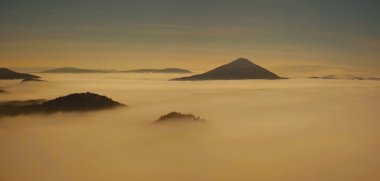 bohem-saxony İsviçre'nin güzel bir dağ sunrise gece dolunay. kumtaşı zirveleri ve sisli arka plandan arttı tepeler turuncu güneş ışınları nedeniyle sis olduğunu.