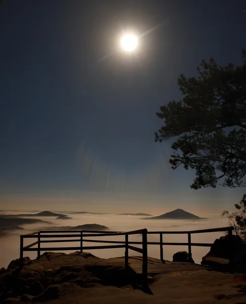 Noche de luna llena con salida del sol en una hermosa montaña de la Suiza bohemia-sajona. Picos de arenisca y colinas aumentadas de fondo brumoso, la niebla es de color naranja debido a los rayos del sol . — Foto de Stock