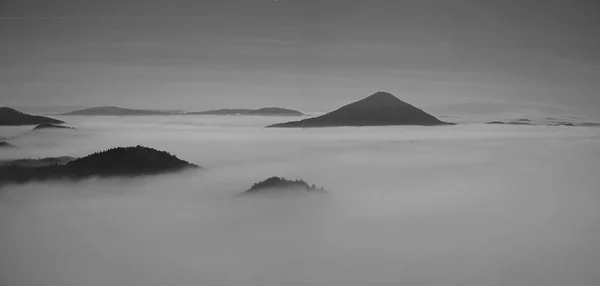 Full moon night with sunrise in a beautiful mountain of Bohemian-Saxony Switzerland. Sandstone peaks and hills increased from foggy background. First sun rays. Black and White photo. — Stock Photo, Image