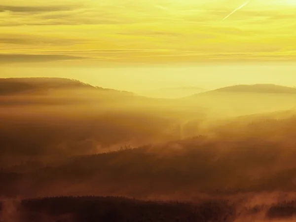 Autumn sunrise in a beautiful mountain of Bohemia. Peaks of hills increased from fog. — Stock Photo, Image