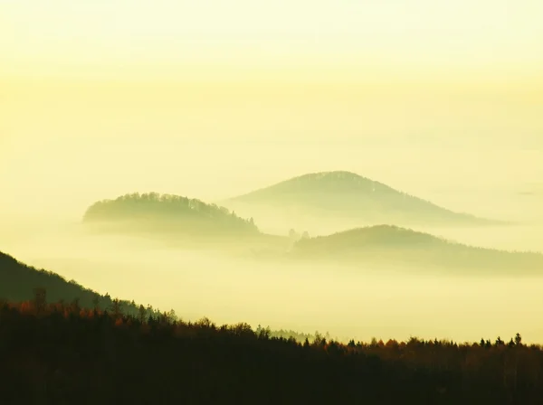 Autumn sunrise in a beautiful mountain of Bohemia. Peaks of hills increased from fog. — Stock Photo, Image