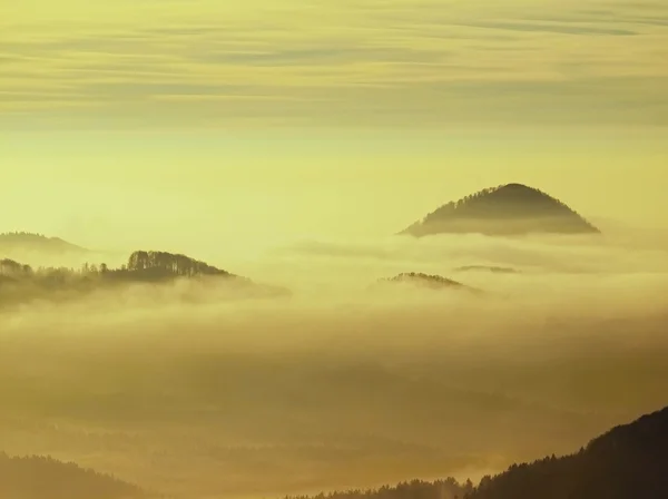 Herbstsonnenaufgang in einem wunderschönen Berg von Böhmen. Berggipfel vermehrt aus Nebel. — Stockfoto