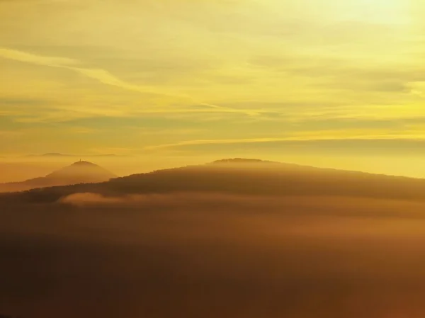 Herbstsonnenaufgang in einem wunderschönen Berg von Böhmen. Berggipfel vermehrt aus Nebel. — Stockfoto