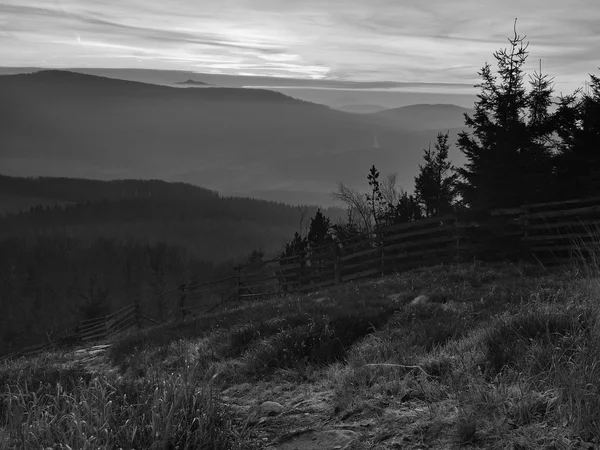 Die Hügel nahmen vom frühmorgendlichen herbstlichen Nebelhintergrund zu. Schwarz-Weiß-Foto. — Stockfoto