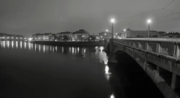 Vue panoramique nocturne sur la rivière et le vieux pont pierreux entre les quartiers historiques de la ville — Photo