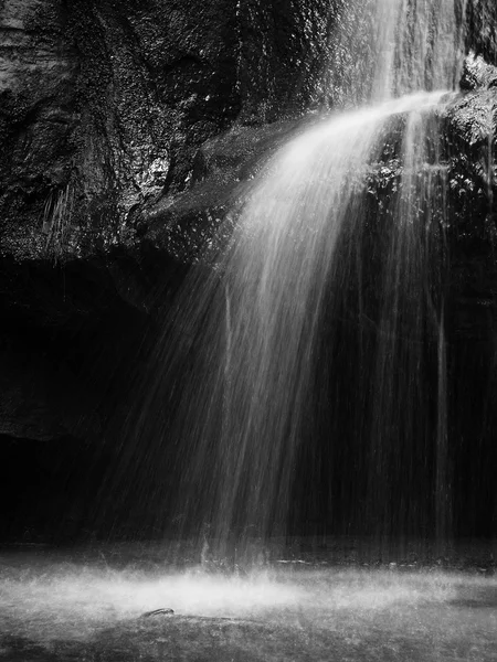 Trapsgewijs op kleine bergbeek, water wordt uitgevoerd over mossy zandstenen rotsen en belletjes maken op niveau melkachtig water. gevallen bladeren op stenen en in water. zwart / wit foto. — Stockfoto