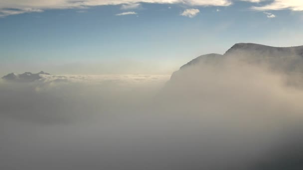 Pico de montañas en la estación de esquí están sobresaliendo de la niebla baja . — Vídeo de stock