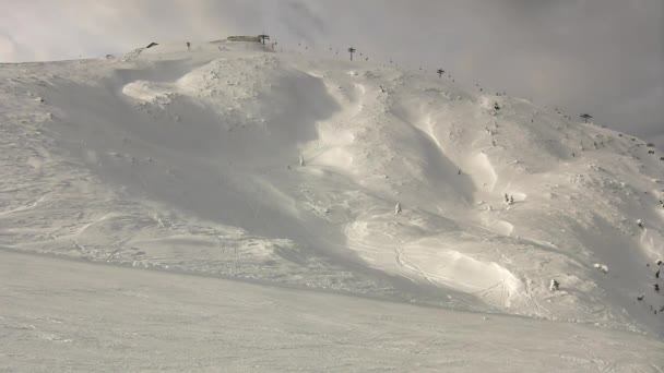 Vrchol hor v lyžařském areálu jsou trčí z nízké mlhy. krásný zimní den mezi vrcholky Alp. — Stockvideo