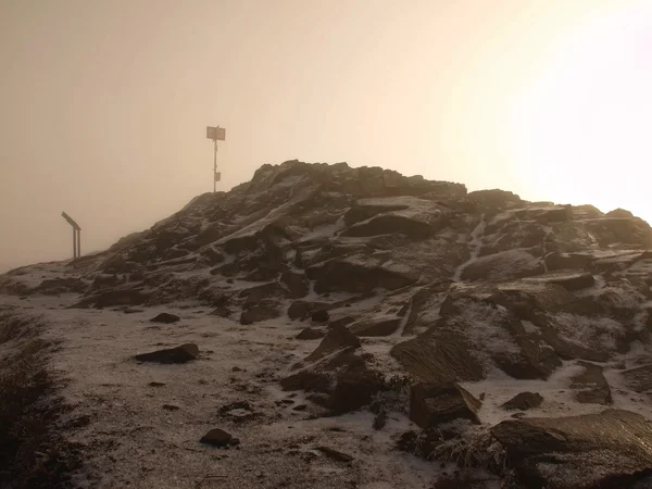 Topp av basalt berg omfattas av hoartfrost, orange fogy himlen med kallt solen i bakgrunden. — Stockfoto