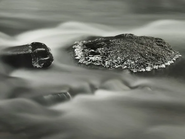 Grande pierre avec de petites glaçons dans l'eau trouble laiteuse du ruisseau de montagne. Temps froid d'hiver — Photo