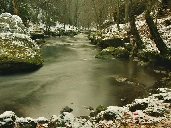 Pedras de arenito grandes na margem de rio e na água limpa do fluxo. O inverno está começando no rio da montanha . — Fotografia de Stock