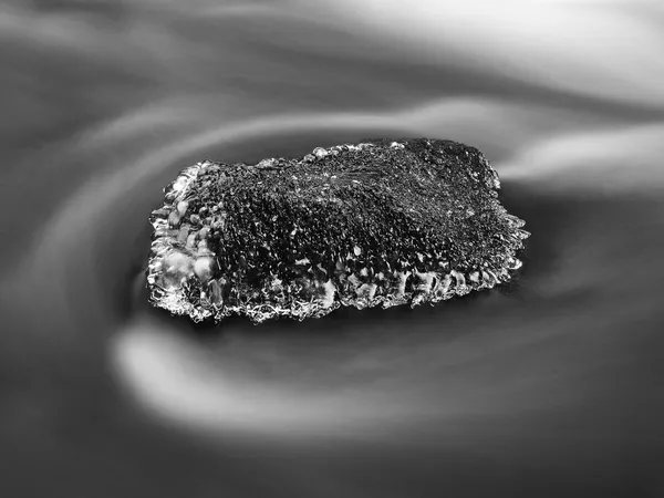 コケに覆われた砂岩のボルダーの山の川の暗い冷たい水でフリーズします。ストリームのミルキーぼやけている水の上の小さい氷柱キラキラ. — ストック写真