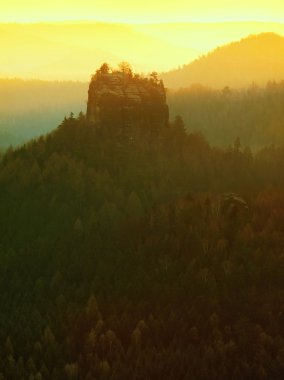 Sunrise güzel dağ çek-Saksonya İsviçre. kumtaşı doruklarına sisli arka plandan arttı, sis turuncu güneş ışınları nedeniyle olduğunu.