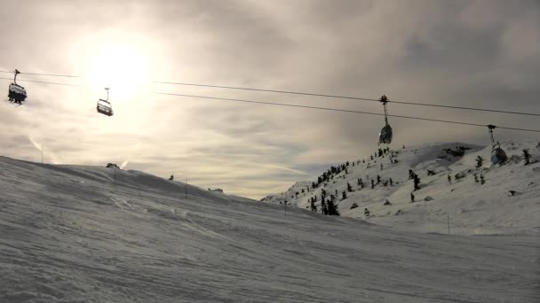 Corde de course bien au-dessus de la neige fraîche sur la pente dans la station de ski. Soleil du soir dans un ciel nuageux . — Video