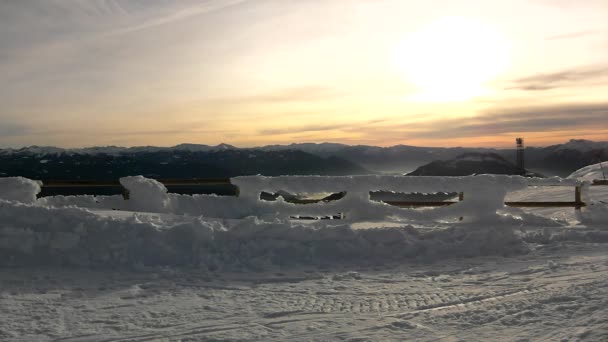 Besneeuwde hek op bergtop in zonnige winterdag. scherpe zonnestralen make reflectie in ijzig sneeuw korst — Stockvideo