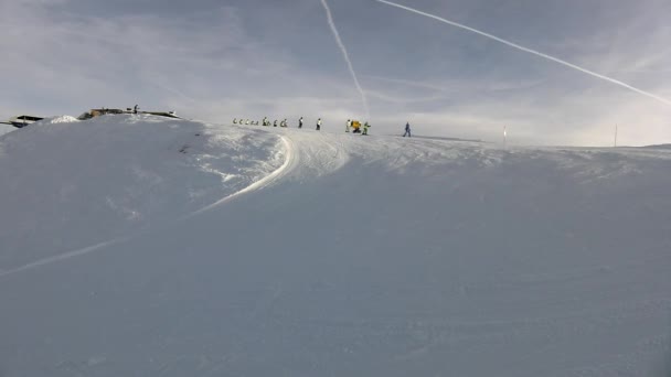 Piek van de berg met helling voor skiën in de Alpen skiresort, stelletje skiërs van Skischool genieten van verse poeder sneeuw op de helling. zonnige winterdag in Alpen. — Stockvideo