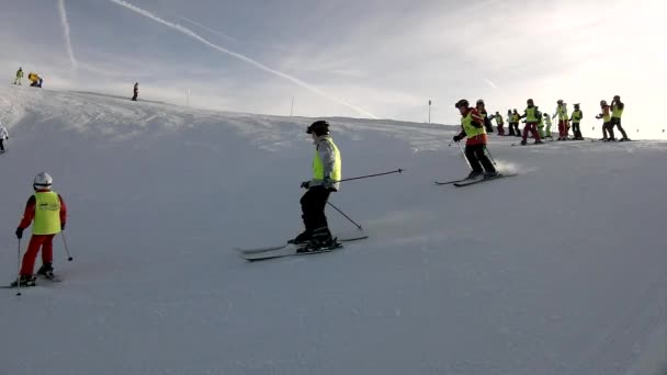 Csúcs hegy lejtőjén a lesiklás Alpok síközpont, csomó síelők a ski school friss porhó lejtőn élvez. napsütéses téli nap-Alpokban. — Stock videók