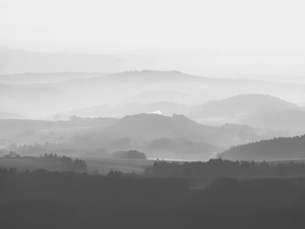 Autumn sunrise in a beautiful mountain of Bohemia. Peaks of hills increased from foggy background, the fog with sun rays. — Stock Photo, Image