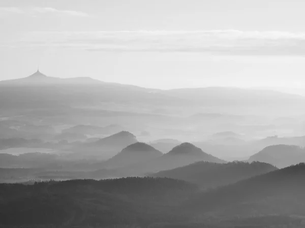 Outono nascer do sol em uma bela montanha da Boêmia. Picos de colinas aumentadas a partir de fundo nebuloso, o nevoeiro com raios de sol . — Fotografia de Stock