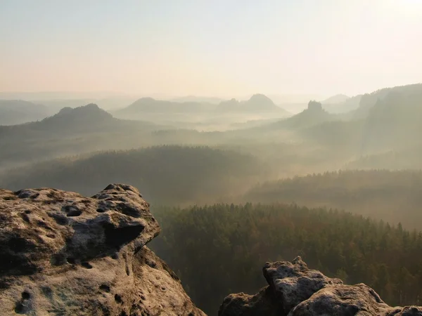 Spring sunrise in a beautiful mountain of Czech-Saxony Switzerland. Sandstone peaks increased from foggy background, bright trails of sun rays in mist. — Stock Photo, Image