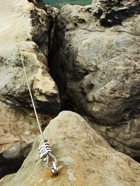 Fácil vía ferrata en roca arenisca de Sajonia Suiza. Cuerda retorcida de hierro fijada en bloque por tornillos ganchos a presión . — Foto de Stock