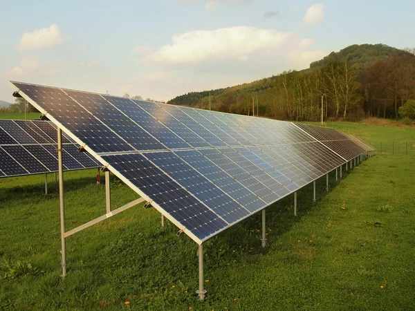 Paysage industriel avec centrale photovoltaïque sur prairie avec herbe verte . — Photo