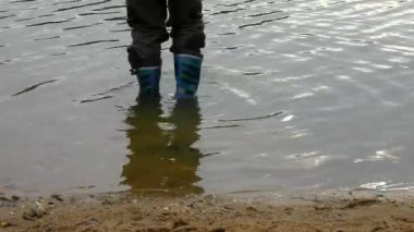 genç çocuk lastik çizmeleri çamurlu su birikintisi yıkama