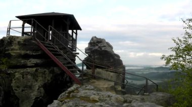 Rock görünümü olarak ana tepe üzerinde ahşap kabin işaret gökyüzünde kara bulutlar. Yaz kumtaşı kaya sabahın erken saatlerinde.