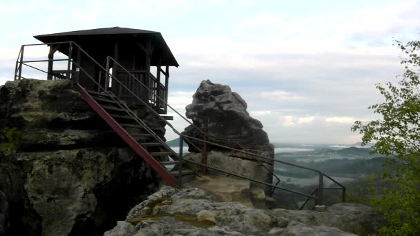 Holzhütte auf dem Hauptfelsen als Aussichtspunkt, dunkle Wolken am Himmel. Sommer frühmorgens in Sandsteinfelsen. — Stockvideo