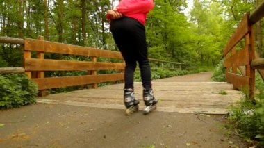 pembe ve siyah spor giyim siyah kırmızı beyaz paten adam ile adam için portre görünümünde hızla blading asfalt yolda Park, çim ve yere bırakır