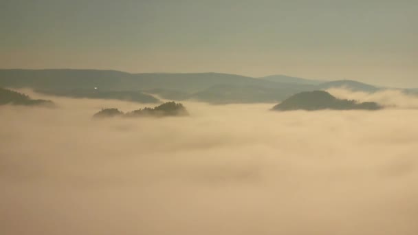 Magnífico amanecer brumoso en una hermosa montaña de picos rocosos de arenisca. Las rocas afiladas aumentaron de fondo brumoso, la niebla está temblando en el valle — Vídeo de stock