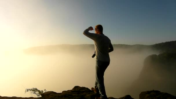 Photograph in action within magnificent misty sunrise in a beautiful mountain of sandstone rocky peaks. Sharp rocks increased from foggy background, the fog is shaking in valley — Stock Video