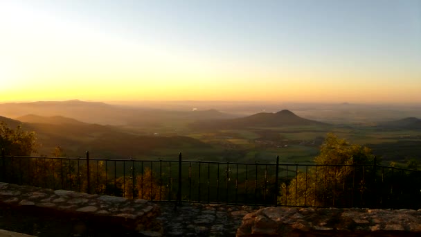 Blick durch Buchenzweige auf Sonnenuntergang und tiefe Talwälder darunter — Stockvideo