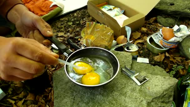 Koken in de natuur op kleine camping fornuis, Roerei op pan voor betaalbaar. versluiering van kleine camping spatel op oppervlak van niet-stick koekenpan. — Stockvideo