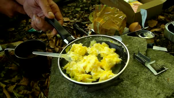 Cooking in nature on small camping cooker, scrambled eggs on pan for breakfest. Scrambling of small camping spatula on surface of non-stick frying pan. — Stock Video