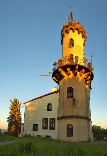 Altes Gebäude der Wetterwarte. hoher Turm mit Antennen. Frühlingsmorgen auf dem Gipfel des Hügels. — Stockfoto